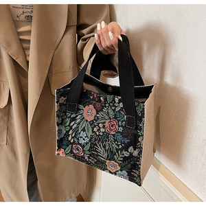 Detail of floral tapestry handbag with rose embroidery and beige linen side panel