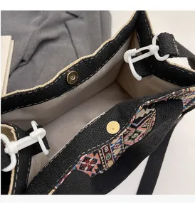 Detail of black canvas tote with ethnic geometric trim and magnetic gold clasp