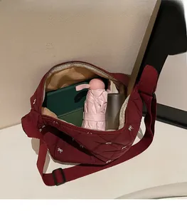 Detail of burgundy quilted tote showing spacious interior with umbrella and notebook