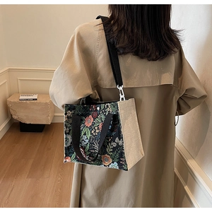 Floral tapestry tote bag detail featuring embroidery and contrast linen side panel