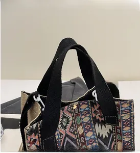 Detail of reinforced black strap on canvas tote bag with vibrant geometric patterns