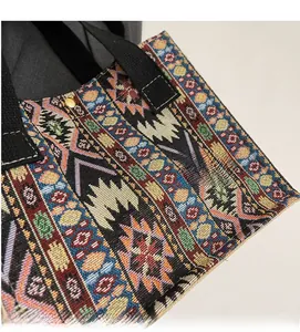 Detail of colorful ethnic woven fabric tote bag with black handles and vintage bronze clasp