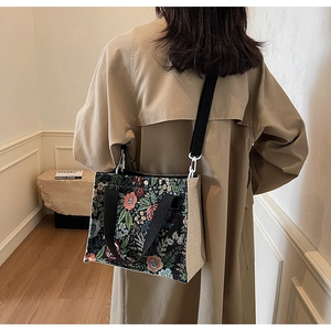 Rear view of a floral jacquard tote bag featuring canvas side panels and black strap
