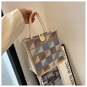 Detail of checkered linen handbag with braided rope handle and vintage wooden button
