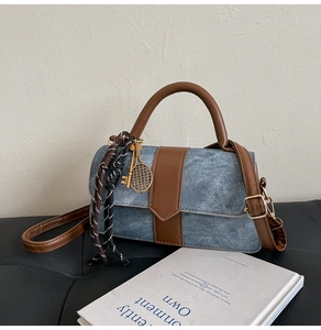 Détail du sac en denim et cuir marron avec breloque de raquette de tennis et tresse