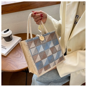 Detailed shot of blue and brown checkered linen tote bag with rope handle and wooden button
