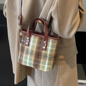 Classic checkered wool bucket bag with brown leather handles and adjustable shoulder strap