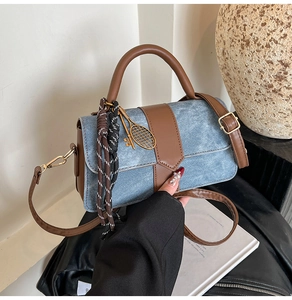 Détail du sac à main en denim bleu et cuir avec breloque raquette de tennis et pendentif