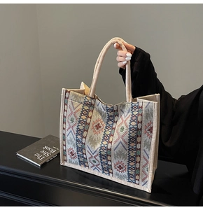 Close-up of bohemian linen tote bag featuring woven rope handles and tribal floral patterns