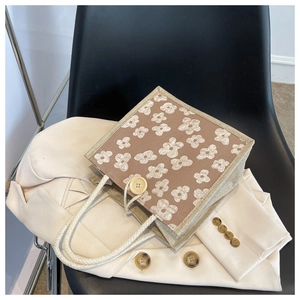 Close-up of brown floral linen tote bag featuring a wooden button and white rope handles