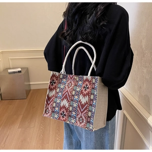 Close-up of bohemian woven tote bag with rope handles and ethnic geometric pattern