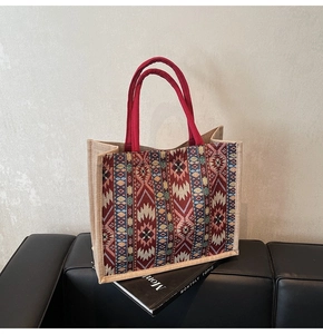 Detailed close-up of woven linen tote bag with geometric tribal pattern on a magazine
