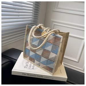Close-up of the woven texture and large wooden button detail on the checkered tote bag