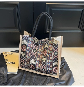 Detail of a large linen tote bag showing ethnic geometric patterns and woven handles