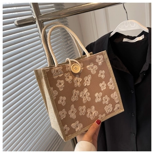 Detail of linen tote bag featuring 3D floral applique and rustic wooden button closure