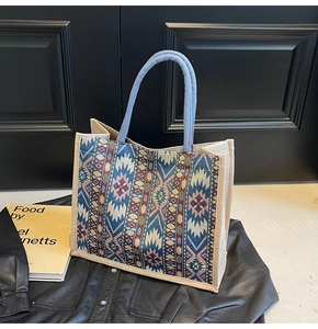 Close-up of linen tote bag featuring ethnic geometric patterns and blue rope handles