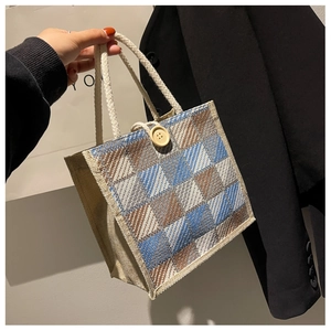 Detail of checkered linen tote bag featuring hemp rope handles and a wooden button closure