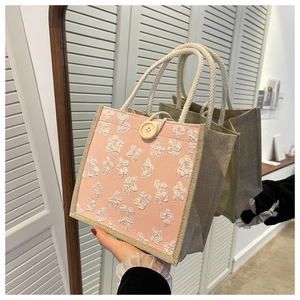Detail of linen tote bag with 3D floral texture, large button and hemp rope handle