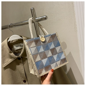 Detail of checkered linen tote with wood button closure and cotton rope handles