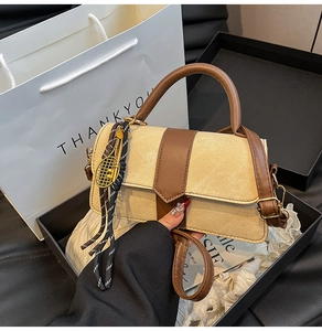 Détail d'un sac à main en toile vintage avec garniture en cuir brun dans son coffret