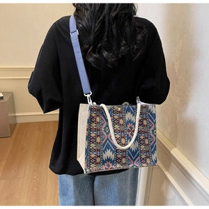 Detailed back view of a woven ethnic canvas tote bag with adjustable blue strap