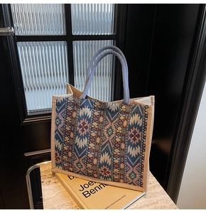 Close-up of geometric woven linen tote bag with colorful ethnic patterns and rope handles