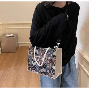 Ethnic bohemian woven tote bag with colorful geometric patterns shown in a lifestyle setting