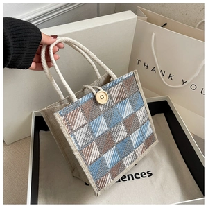 Detail of blue and brown checkered linen handbag with cotton rope handle and wood button