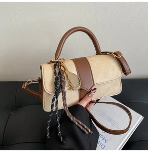 Vue détaillée du sac à main beige et marron avec breloque raquette et cordon tressé élégant