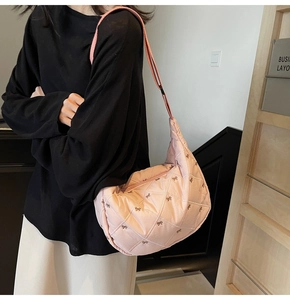 Detail of pink quilted tote bag with brown bow embroidery and adjustable shoulder strap