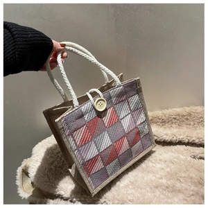 Detail shot of a plaid linen handbag with cotton rope handles and decorative button