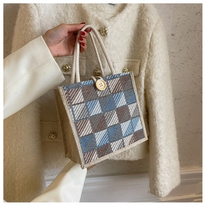Detail of woven linen tote bag with checkered pattern and durable rope handles