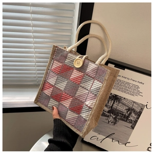 Close-up of linen tote bag featuring a red and grey argyle pattern and white rope handles