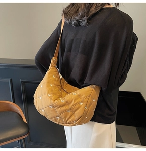 Detail of mustard yellow quilted crescent bag with delicate white bow embroidery
