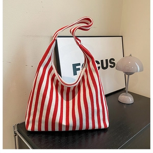 Detail of red and white striped canvas tote bag in a minimalist lifestyle setting