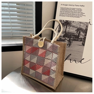 Close-up of linen tote bag featuring woven plaid pattern and a decorative wooden button
