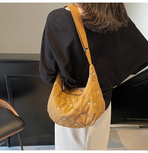 Brown quilted half-moon crossbody bag with white bow embroidery and adjustable strap