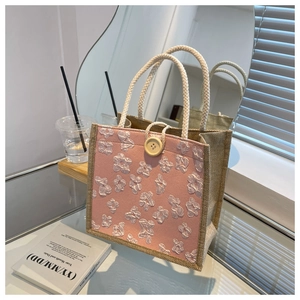 Detail of pink floral texture linen tote bag with wooden button and braided rope handle