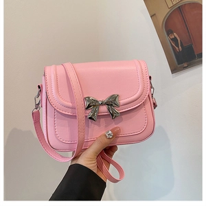 Détail d'un sac bandoulière rose en cuir PU avec boucle décorative en nœud argenté