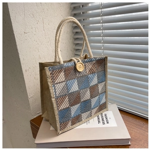 Detailed close-up of a plaid jute tote bag with rope handle and a decorative wood button