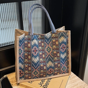 Boho linen tote bag with geometric pattern and blue rope handles on a stone table