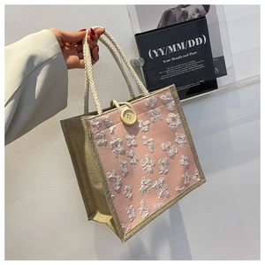 Detail of pink floral fabric and natural jute texture on a chic handmade tote bag