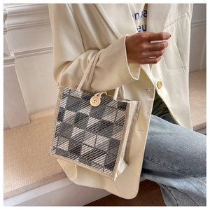 Linen plaid handbag featuring a wooden button closure and rustic rope handle detail