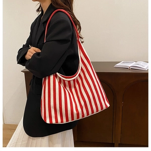 Vertical red and white striped canvas tote bag shown with model in professional attire