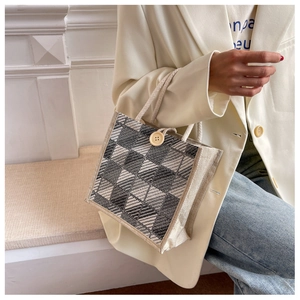 Detail of checkered linen handbag with wooden button closure and rope handle on model