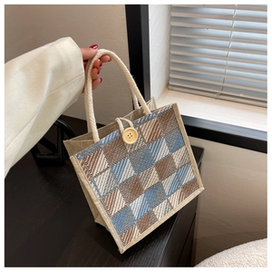 Close-up of linen tote bag with checkered pattern and wooden button closure