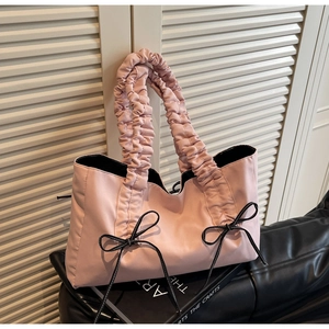 Detailed view of pink bow tote bag with ruched handles and satin finish fabric