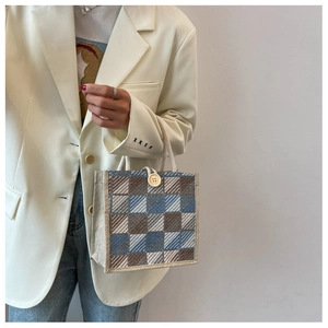 Detailed shot of a plaid woven mini tote bag with white rope handles and a large button clasp