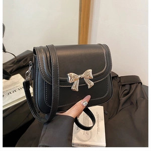 Détail du nœud argenté et des coutures sur le sac à bandoulière en cuir PU noir