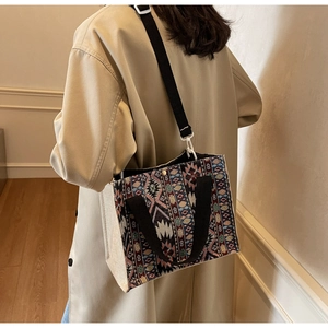 Ethnic woven tote bag detail showing intricate geometric patterns and beige linen texture
